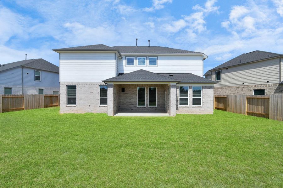 Experience outdoor living at its finest on this expansive covered patio, thoughtfully designed for BBQs and delightful outdoor dining. Sample photo of completed home with similar floor plan. Actual colors and selections may vary.