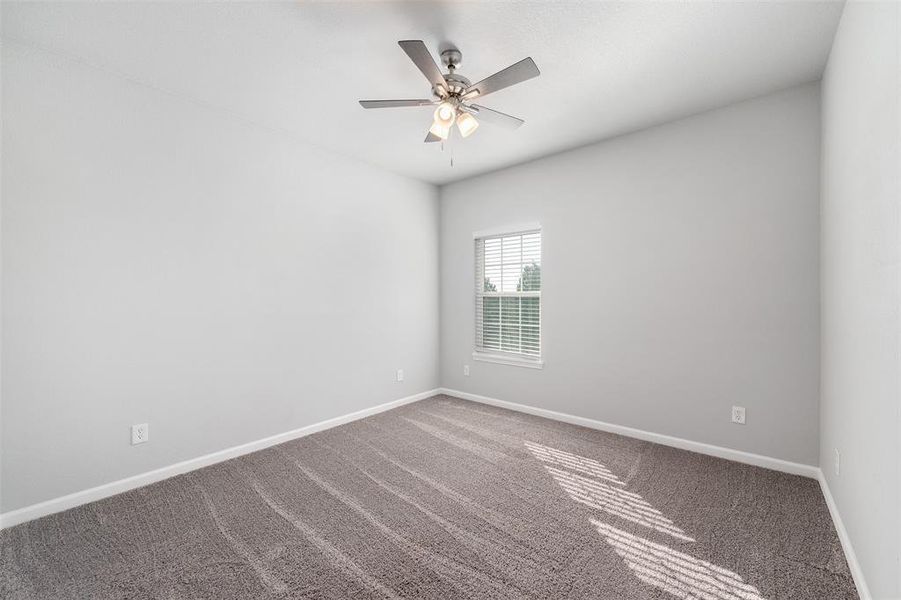 Unfurnished room with ceiling fan and carpet