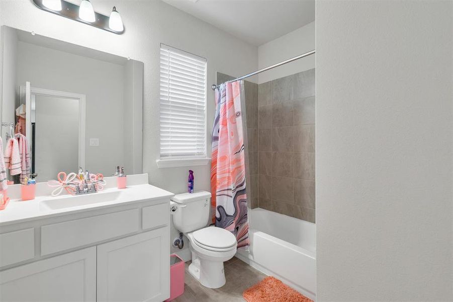 Bathroom featuring a white vanity with integrated sink, chrome faucet, and a large mirror