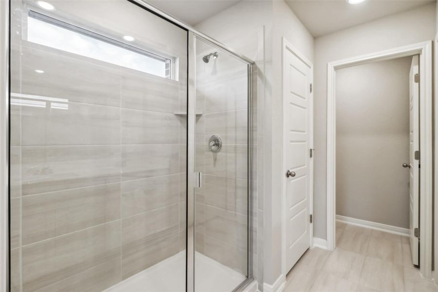 Bathroom with a shower stall and baseboards Bathroom with a shower stall and baseboards