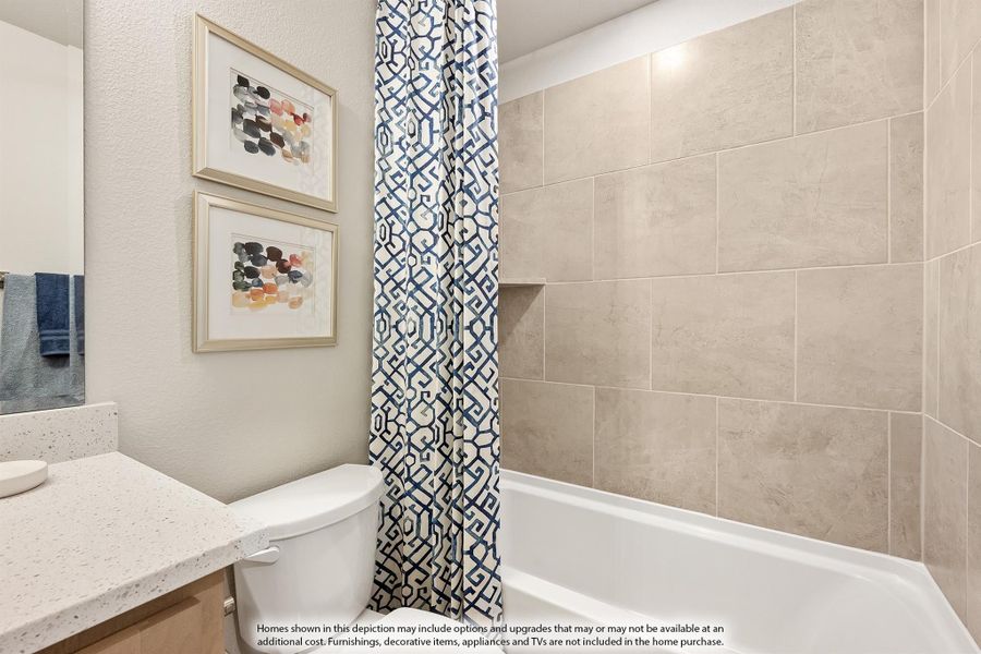 Bathroom with quartz countertop, soaking tub, tile surround, and blue patterned shower curtain Bathroom with quartz countertop, soaking tub, tile surround, and blue patterned shower curtain