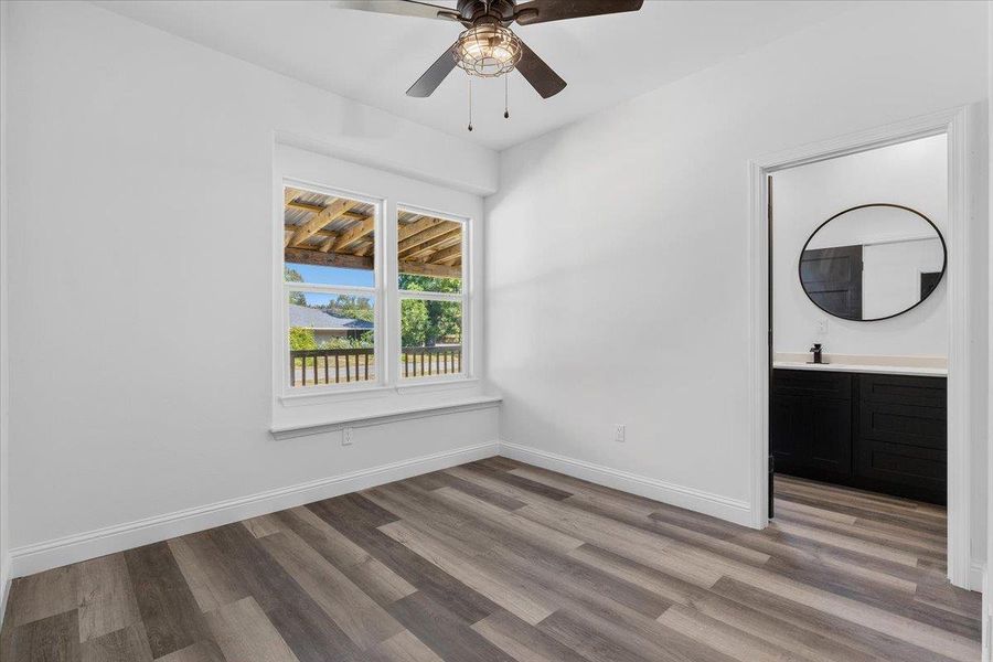 Rich wood-look flooring and crisp trim highlight this versatile bedroom space featuring a built-in window sill. Rich wood-look flooring and crisp trim highlight this versatile bedroom space featuring a built-in window sill.