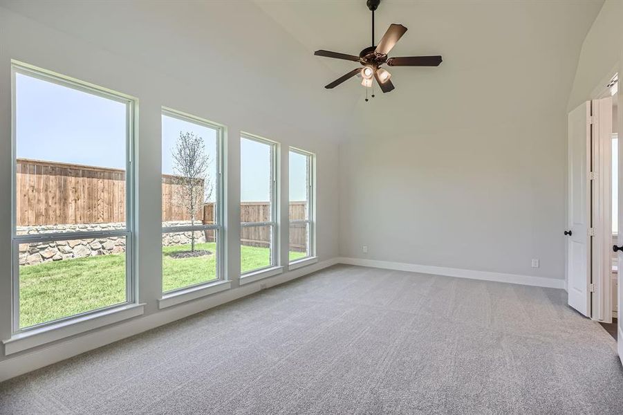 Spare room featuring carpet, ceiling fan, high vaulted ceiling, and baseboards Spare room featuring carpet, ceiling fan, high vaulted ceiling, and baseboards