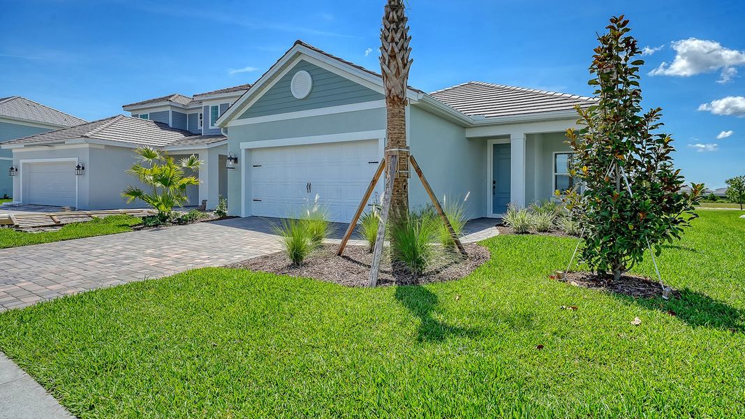 Front exterior of a new home in Palmera Real Estate and Homes for Sale in Venice, FL - Neal Communities, Venice, FL, highlighting curb appeal (Image 2). Front exterior of a new home in Palmera Real Estate and Homes for Sale in Venice, FL - Neal Communities, Venice, FL, highlighting curb appeal (Image 2).