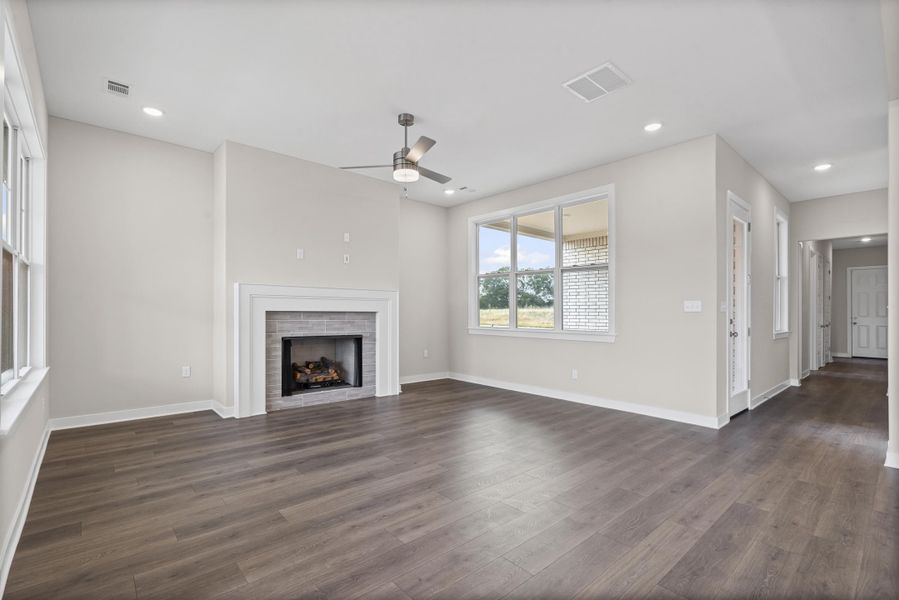 Unfurnished living room featuring recessed lighting, dark wood finished floors, a fireplace, and a ceiling fan
