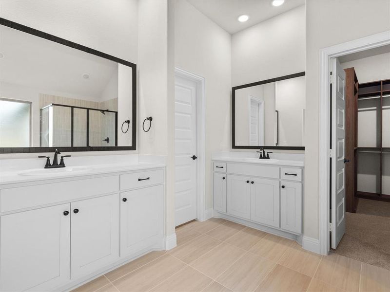 Bathroom with two vanities, a stall shower, recessed lighting, and a spacious closet