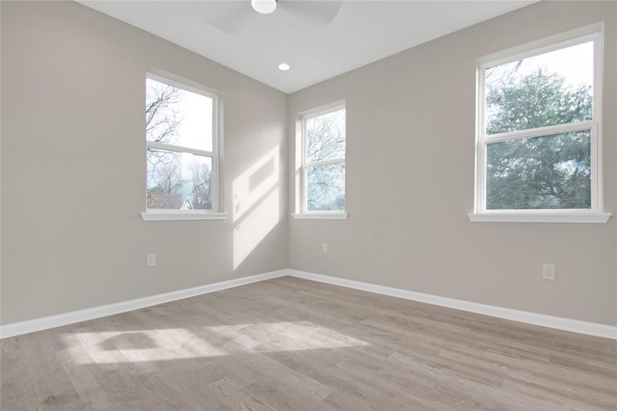 Spare room with light wood-type flooring, a ceiling fan, and recessed lighting