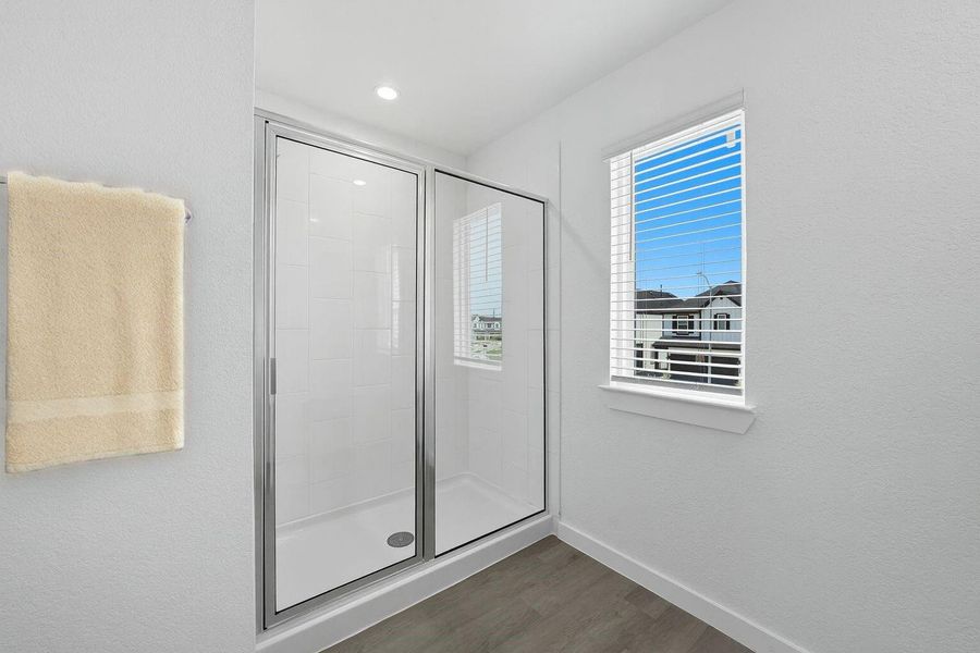 The standing shower in the primary bathroom offers plenty of space and the private window adds some beautiful light during yoru daily rituals.