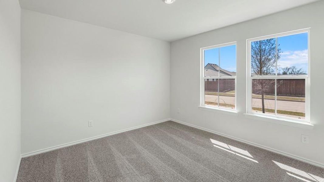 Room featuring two windows, neutral wall color, gray patterned carpet, white baseboards, and a recessed ceiling light