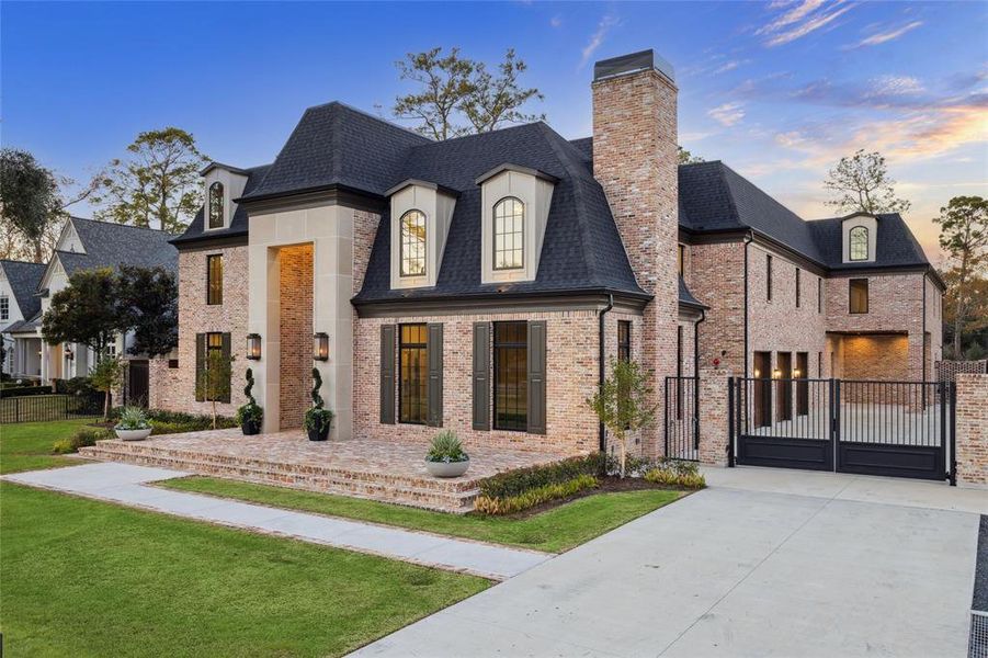 The soaring double-height entry offers a striking first impression, framed by elegant lanterns and grand double doors. Thoughtfully designed with timeless architectural details, this inviting entrance sets the tone for the refined luxury and impeccable craftsmanship found throughout the home.