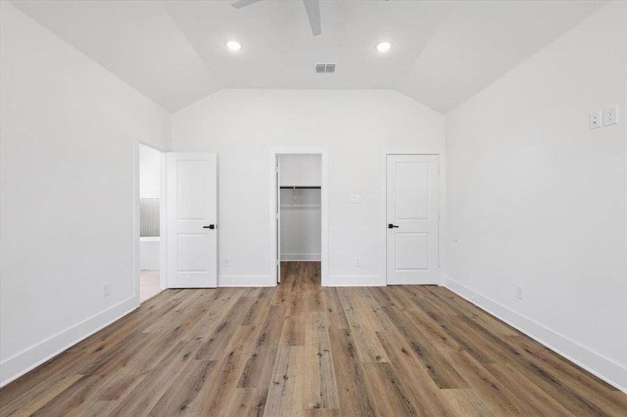 Unfurnished bedroom with ceiling fan, and a spacious closet