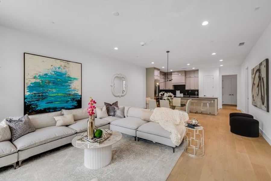 Living room with visible vents, light wood-style flooring, and recessed lighting