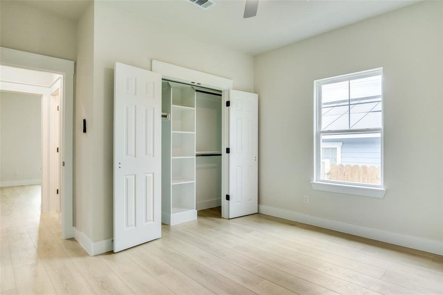 Unfurnished bedroom with light wood-style floors, baseboards, and a closet