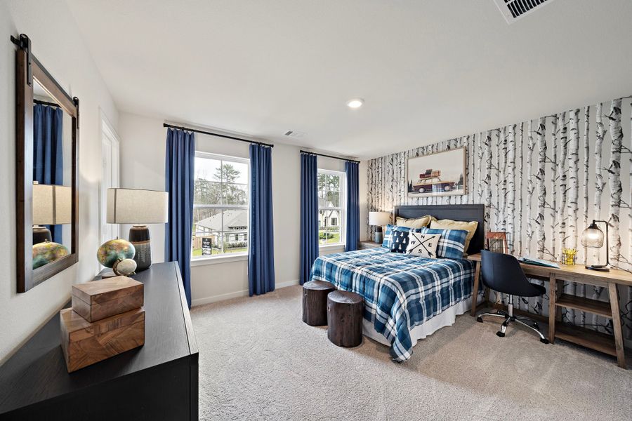 A bedroom with a bed and a desk.