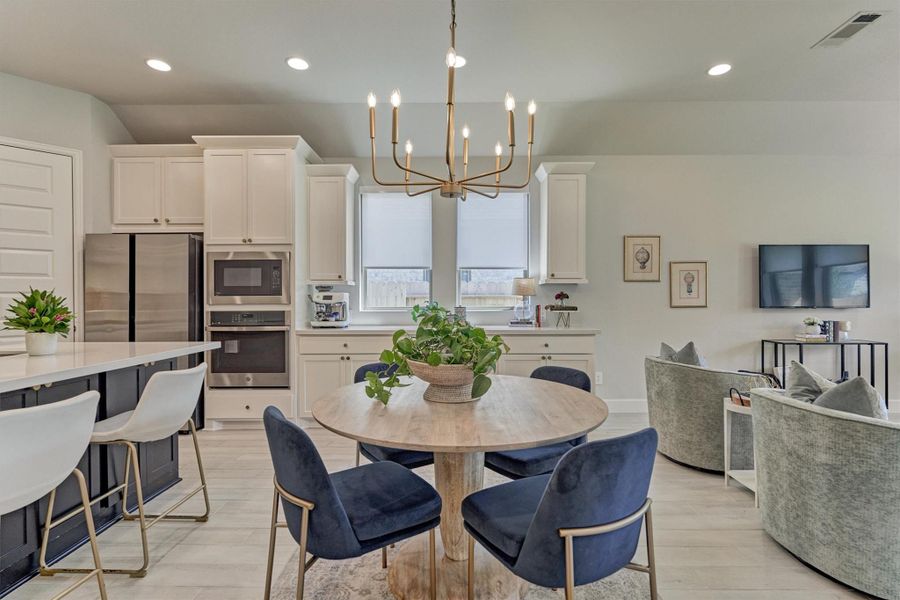 Brushed gold chandelier in this inviting open-concept floating dining room.