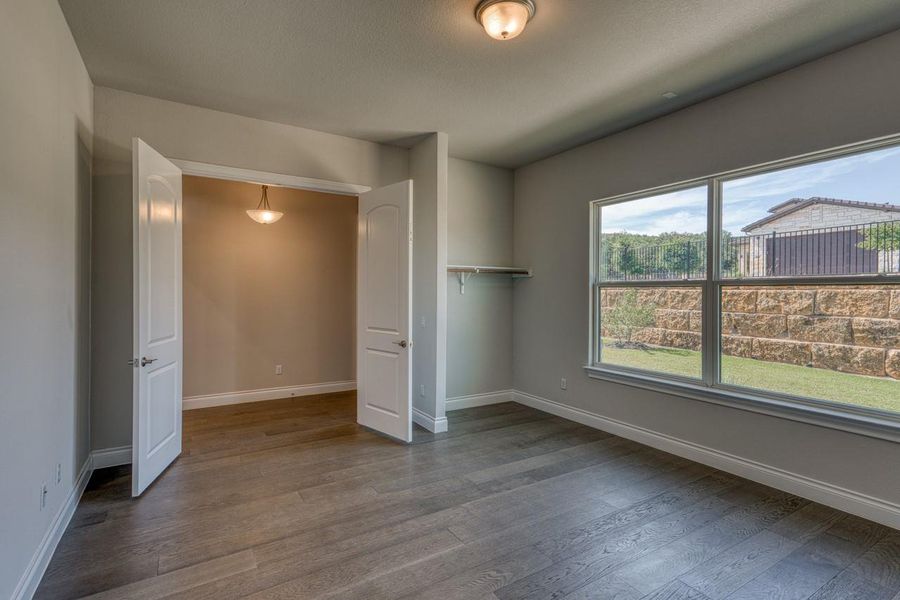 Unfurnished bedroom featuring baseboards and dark wood-type flooring