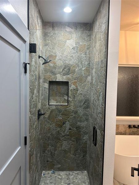 Bathroom featuring a stall shower and a tub