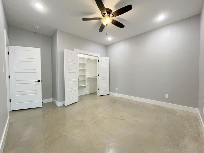 Unfurnished bedroom with a closet, ceiling fan, and a spacious closet