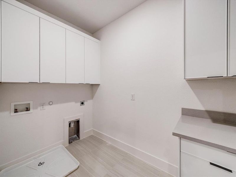 Laundry area featuring gas dryer hookup, cabinet space, electric dryer hookup, and hookup for a washing machine Laundry area featuring gas dryer hookup, cabinet space, electric dryer hookup, and hookup for a washing machine