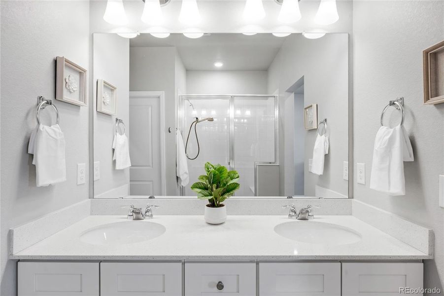 Another view of the primary bathroom with dual vanity