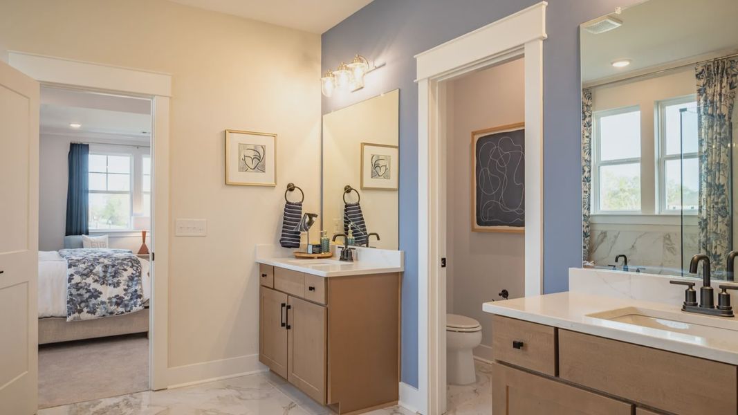 Bright bathroom with split double vanity and water closet