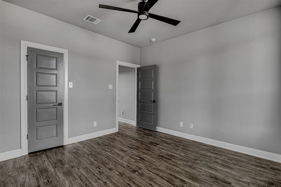 Empty room with ceiling fan and dark hardwood / wood-style flooring