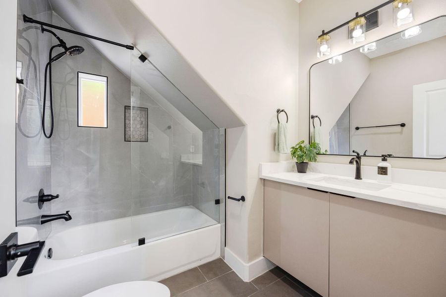 Stylish full bathroom featuring quartz countertops, contemporary finishes, and generous vanity space. Stylish full bathroom featuring quartz countertops, contemporary finishes, and generous vanity space.