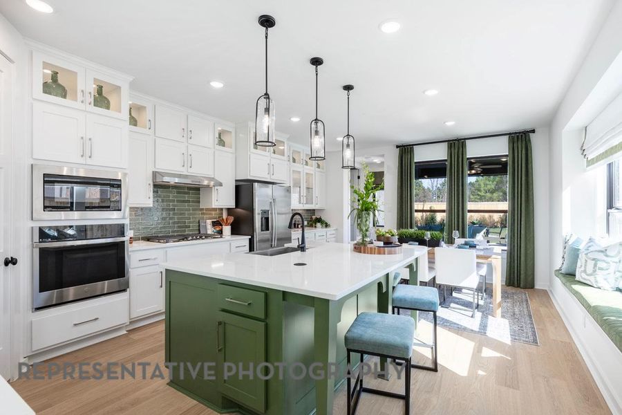 Kitchen with appliances with stainless steel finishes, a sink, light countertops, green cabinetry, and tasteful backsplash Kitchen with appliances with stainless steel finishes, a sink, light countertops, green cabinetry, and tasteful backsplash