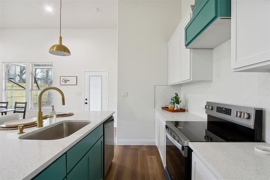 Kitchen with sink, light stone counters, white cabinetry, hanging light fixtures, and appliances with stainless steel finishes