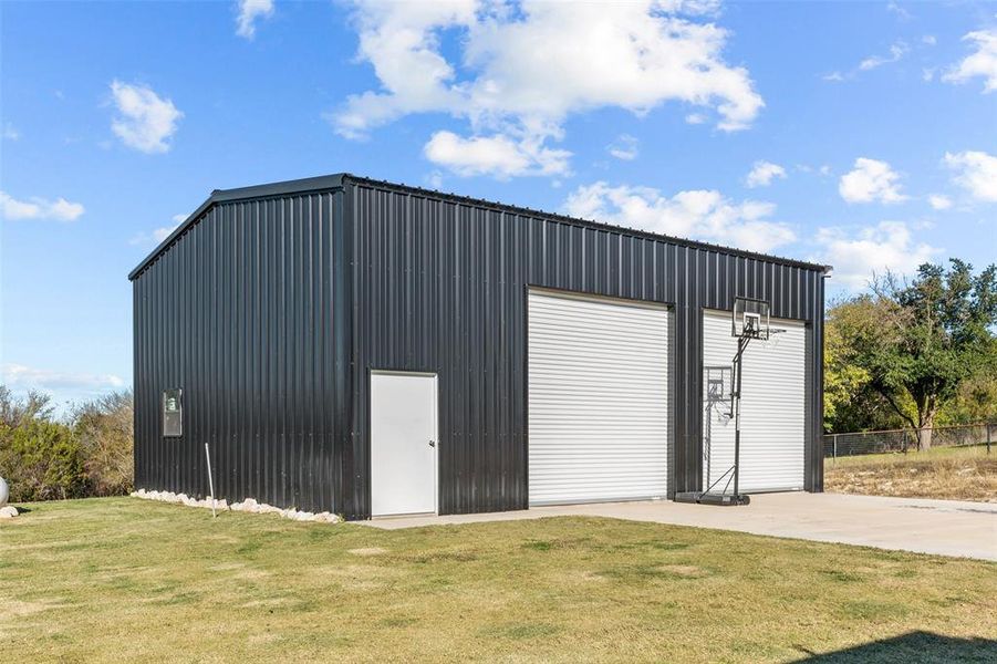 View of outdoor structure with a garage and a yard