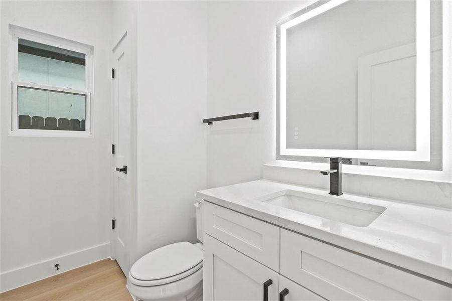 Half bathroom with vanity and light wood-style floors