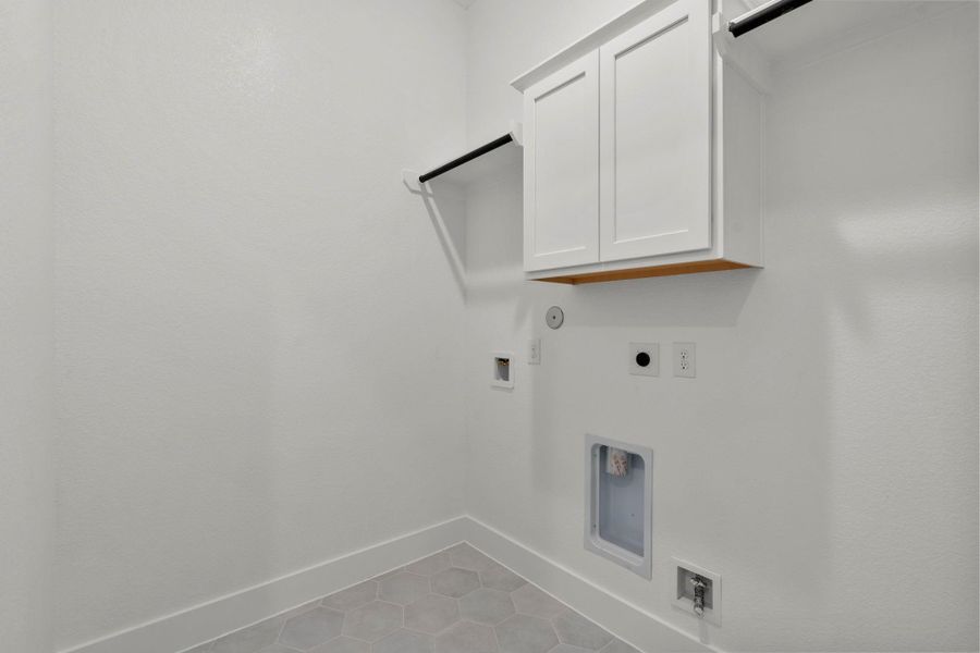 Utility room with tile flooring.