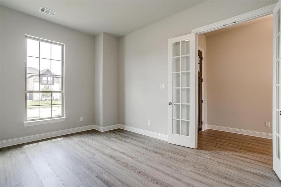 Spare room with light wood-type flooring and french doors