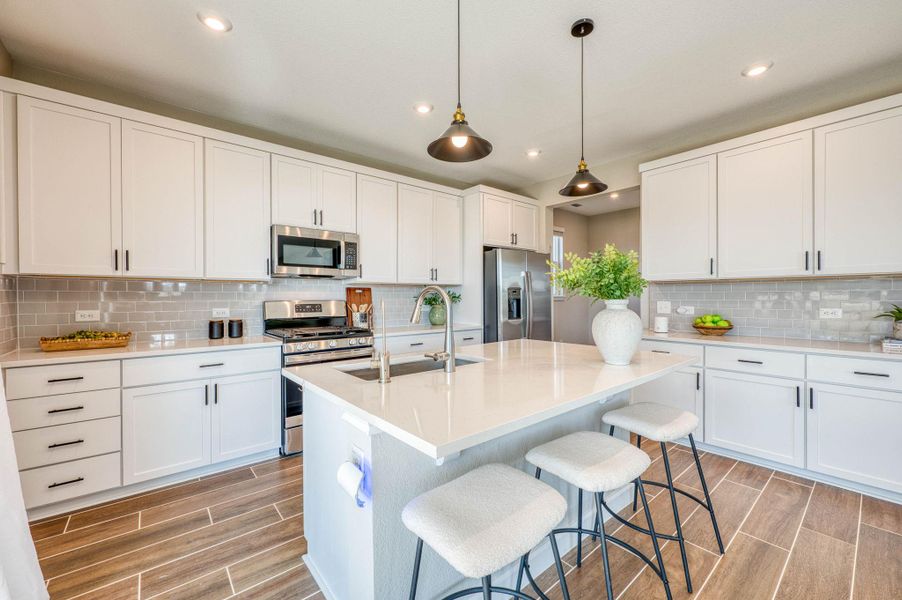 Timeless wood-look tile flooring pairs beautifully with classic white cabinetry and crisp quartz countertops. Timeless wood-look tile flooring pairs beautifully with classic white cabinetry and crisp quartz countertops.