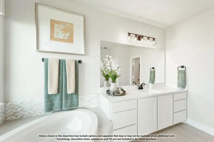 Bathroom with white vanity, large mirror, soaking tub, and geometric tile accent wall Bathroom with white vanity, large mirror, soaking tub, and geometric tile accent wall