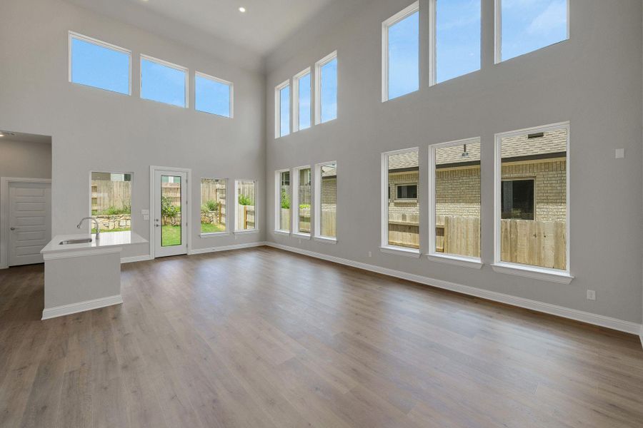 Unfurnished living room with a towering ceiling and dark wood-type flooring Unfurnished living room with a towering ceiling and dark wood-type flooring