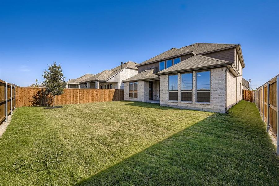 Back of house with a fenced backyard, a shingled roof, brick siding, and a patio area Back of house with a fenced backyard, a shingled roof, brick siding, and a patio area