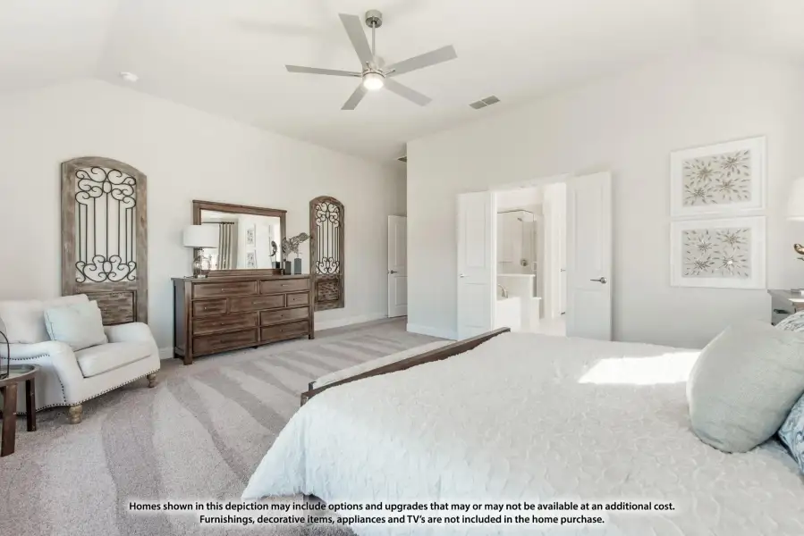 Spacious master bedroom with ceiling fan, carpet flooring, wood dresser, and ensuite bathroom doorway visible.