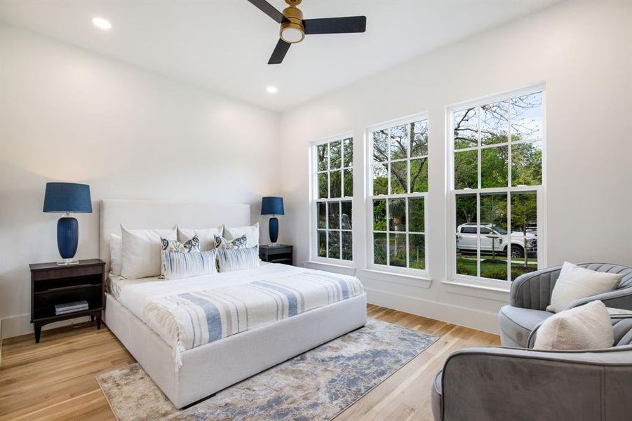 Bright room featuring three large single-hung windows, light wood-finish flooring, and white walls Bright room featuring three large single-hung windows, light wood-finish flooring, and white walls