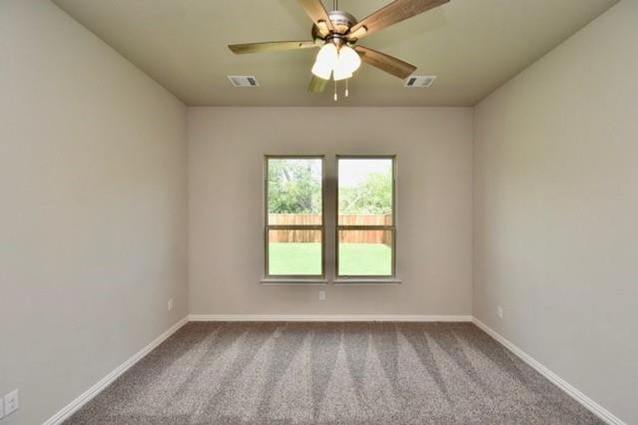 Secondary bedroom with neutral carpet and a ceiling fan Secondary bedroom with neutral carpet and a ceiling fan