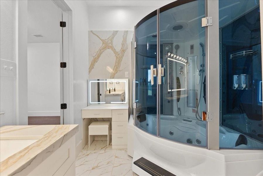 Luxury spa shower with steam features, jets, and built-in seating in Primary bath