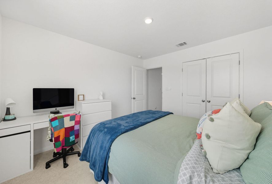 Bedroom with carpet flooring, a closet, and an office area Bedroom with carpet flooring, a closet, and an office area