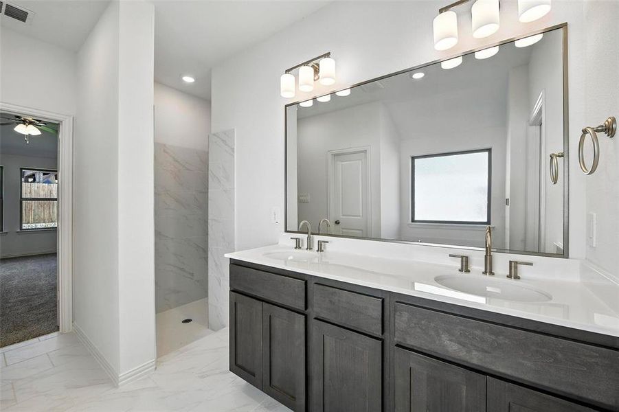 Full bathroom with marble finish flooring, a marble finish shower, double vanity, recessed lighting, and a ceiling fan