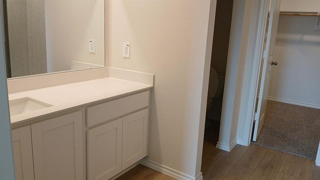 Bathroom vanity featuring a white rectangular sink, light countertop, and white shaker-style cabinetry Bathroom vanity featuring a white rectangular sink, light countertop, and white shaker-style cabinetry