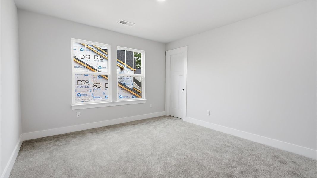 Tasteful bedroom with plush carpet, a walk-in closet, and large windows for abundant natural light Tasteful bedroom with plush carpet, a walk-in closet, and large windows for abundant natural light