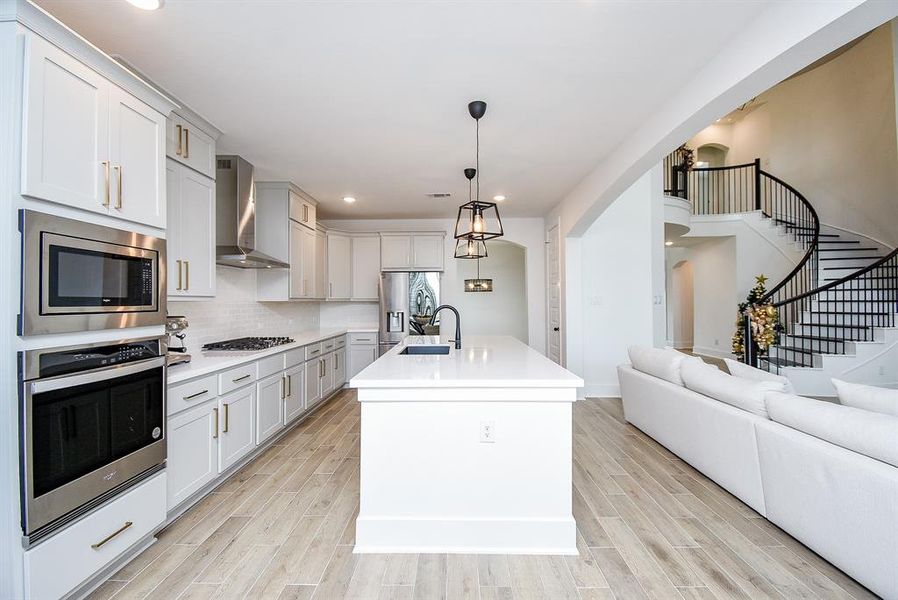 This culinary space features a gas cooktop that allows for precise cooking, while the quartz countertops provide both durability and elegance. The stainless steel appliances add a modern touch, making this kitchen a chef's dream.