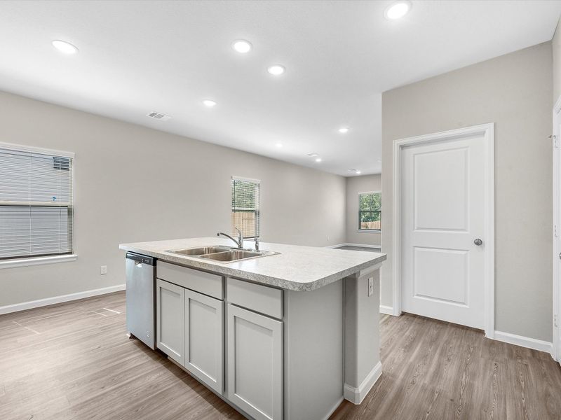 A kitchen with white cabinets.