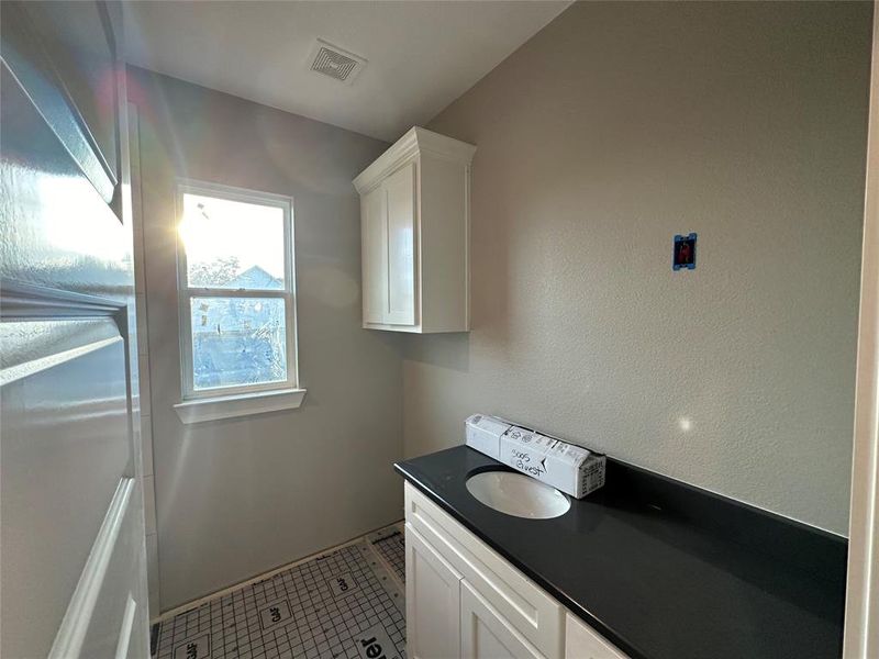 Laundry room featuring light tile patterned floors and sink