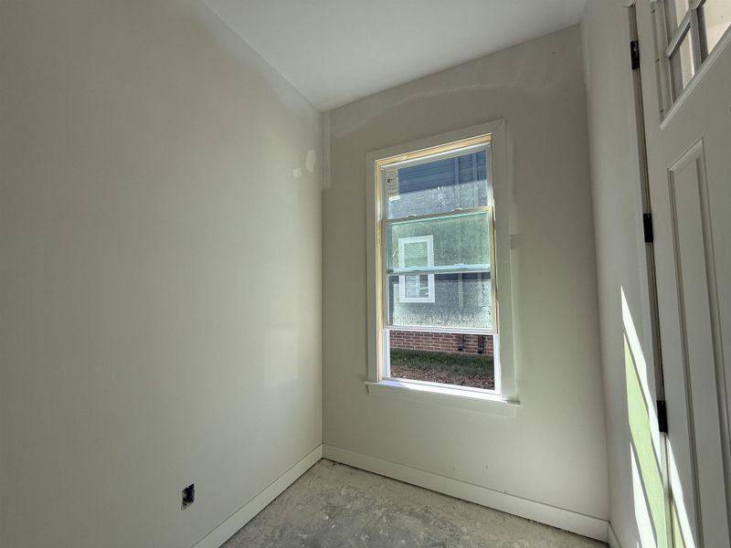 Empty room featuring baseboards and concrete flooring
