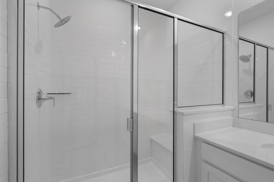 This additional view of your primary bathroom features tile flooring, fresh paint, large walk-in shower, and a large walk-in closet.